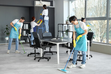 Fototapeta na wymiar Male Asian janitor mopping floor in office