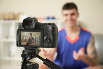 Sporty happy basketball player recording video at home, closeup