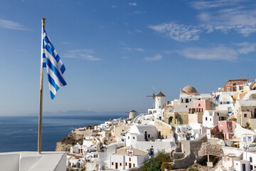 View of Santorini with Greek flag in the foreground