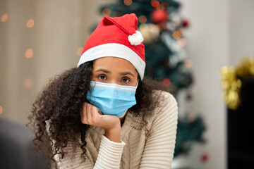 Christmas, medical mask and portrait of woman in living room for pandemic, lockdown or self...