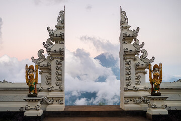 Traditional Balinese temple gate, overlooking the sacred volcano Agung in the clouds, Bali island,...