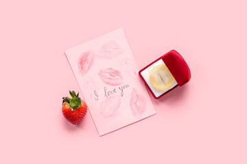 Fresh strawberry, card and engagement box with condom on pink background. Sex education
