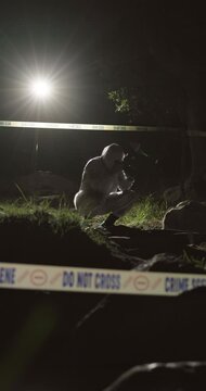 Crime scene, evidence and photograph with forensic team outdoor at night to work on murder case. Accident, investigation and teamwork with people in dark forest for discovery of body or law and order