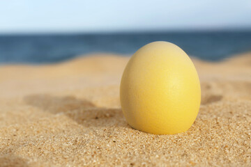 Fototapeta na wymiar Festive painted Easter egg on sea beach