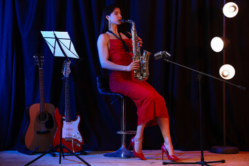 Beautiful woman playing saxophone on stage