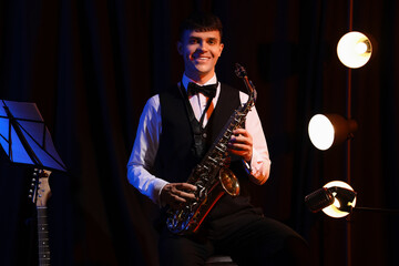 Male artist with saxophone performing on stage