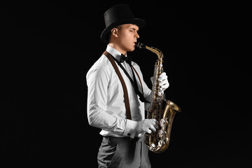 Male artist playing saxophone on black background