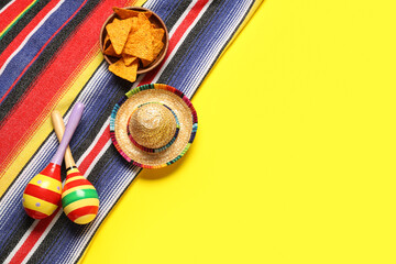 Mexican maracas with sombrero, nachos and serape on yellow background. Cinco de Mayo