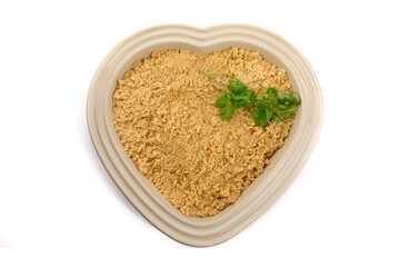 overhead view of a valentines dinner casserole in a heart shaped baking dish isolated on white