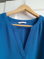 Blue shirt on hangers. Clothes from polyester.