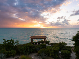 Fototapeta na wymiar empty pergola near ocean overlooking cloudy sunset sky