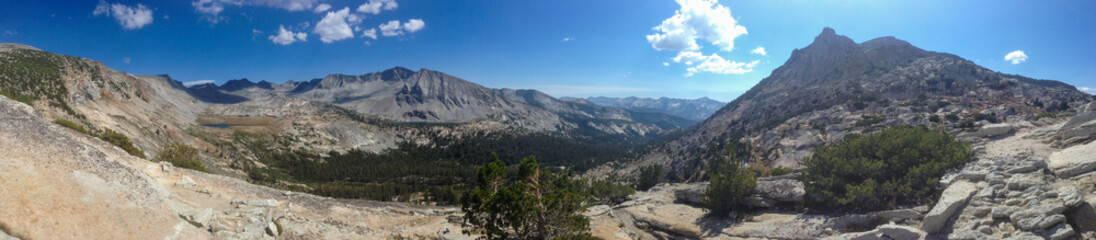 Panoramic sunny scenic view atop hill overlooking mountains on the Yosemite National Park High Sierra Camp trail