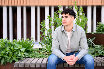 young man in casual clothes sitting outside