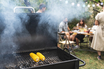 Corn cobs grilling, summer friendly barbecue in the garden concept