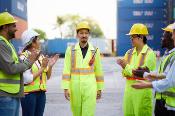Coworkers clapping hands to engineer or worker for success work or project in containers warehouse...