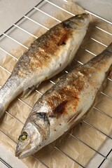 Baked fish on light marble table, closeup