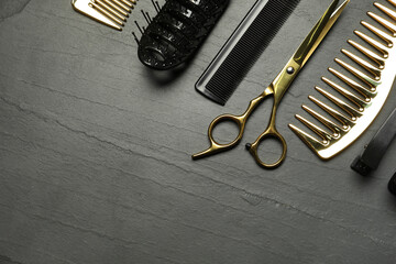 Hairdressing tools on grey textured background, flat lay. Space for text