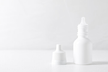 Bottles of medical drops on white background, space for text