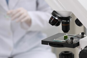 Quality control. Food inspector working in laboratory, focus on microscope