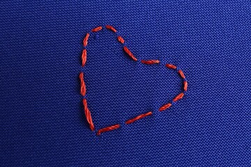 Embroidered heart on blue cloth, top view