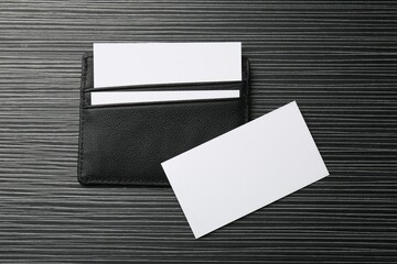 Leather business card holder with blank cards on grey table, top view