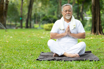 Naklejka na ściany i meble asian senior man meditating and doing yoga in the park