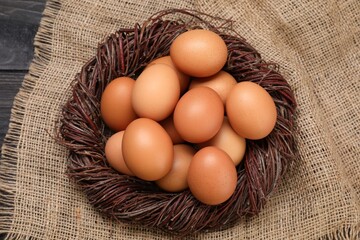 Fresh chicken eggs in nest on table, top view