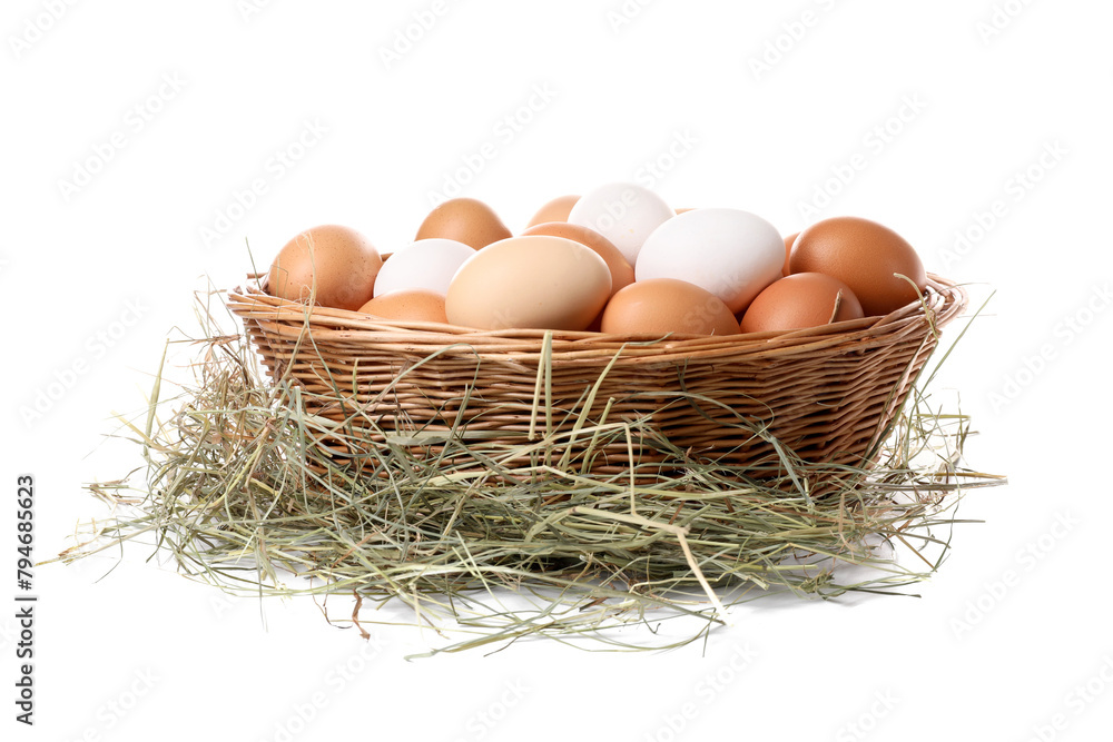 Wall mural Fresh chicken eggs in wicker basket and dried hay isolated on white