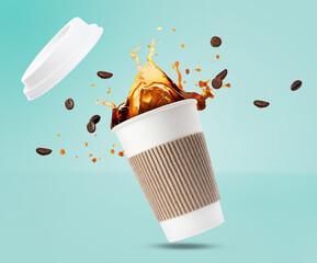 Aromatic coffee in takeaway paper cup and roasted beans in air on turquoise background