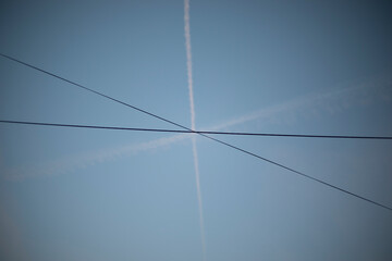 Crossroads of lines. Crossing wires with aircraft air trails.