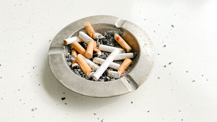 Ashtray full of cigarettes butts close-up on white background