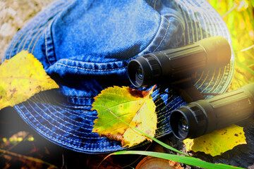 Binoculars, jeans hat, walking in the forest. Traveling, hiking, walking, enjoying vacations