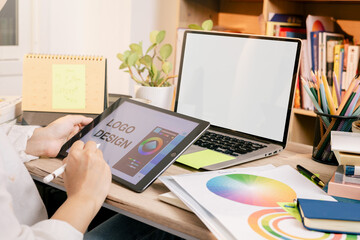 Designers are creating graphic works on tablet and computer. Choosing color shades for work