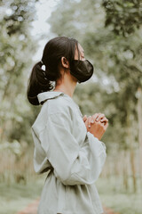 woman standing pleading in the forest