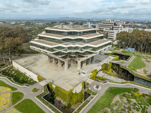 Aerial view of Geysel library at the University of California San Diego, futuristic building, columns holding up upper floor like books, next to the snake path