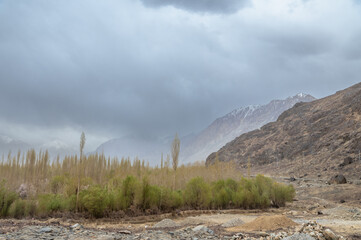 Landscape of Leh, Ladakh. Landscape view of rocky land and green trees surrounded by Himalayas and Dramatic clouds.  