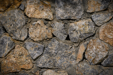 Stone wall texture. Decorative uneven cracked real stone wall surface.2