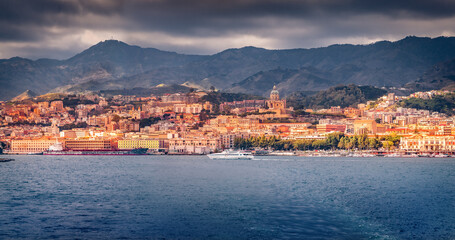 Naklejka na ściany i meble Amazing morning cityscape of Messina port with old colorful buildings, Sicily, Italy, Europe. Dramatic summer seascape of Mediterranean sea. Traveling concept background..