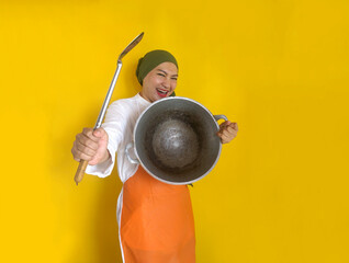 Funny chef Asian woman hold frying pan as a shield and using spatula as a weapon to attack enemies...