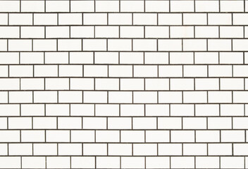 White tiled wall background with rectangular tiles that look like bricks.