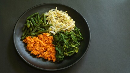 Urap, Indonesia traditional food served on plate. Salad dish consist of steamed vegetables such as...