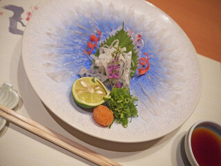 Plate of fugusashi or Japanese fugu blowfish sashimi thin transparent slices