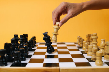 Hand moving chess figure in competition success play. Strategy, management or leadership concept.