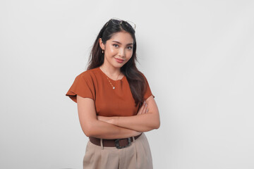Obraz premium Confident Asian woman standing with arms folded and looking at the camera isolated over white background.