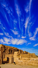 Beautiful cloud patterns and bright blue skies with the mud brick walls and outer remnants of the...