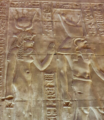 Hathor and Horus accept offerings from the Pharoah Ptolemy in this bas relief in the Temple of Horus at Edfu built during the Ptolemaic era between 237 to 57 BC near Aswan,Egypt - obrazy, fototapety, plakaty