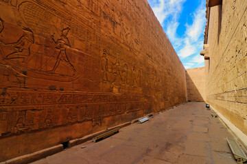 Imposing sandstone walls richly decorated with the story of Horus and Ptolemaic kings in the Temple...