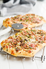 Tasty italian square pizza on kitchen table. - 794763443