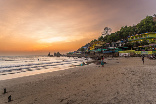 Beautiful sunset at Arabian Sea in the north Goa, India. Stunning sunset behind the sea with waves scene at the Arambol Beach in Goa, famous touristic place for summer vacations.
