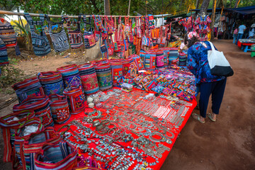 Happy young Indian woman shopping from Anjuna flee market in Goa, India 